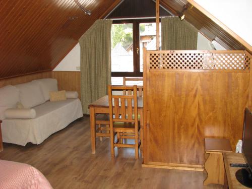 a room with a bed and a couch and a table at Aparthotel Sarrato in Sallent de Gállego