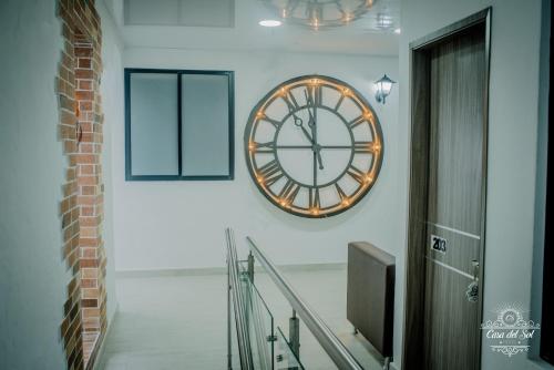 a large clock on the wall in a hallway at Casa del Sol in Villavicencio