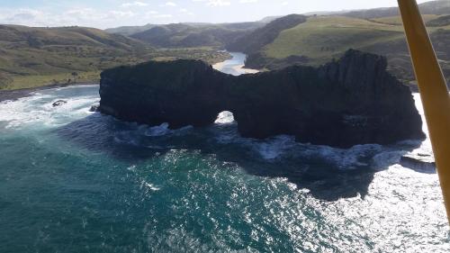 an aerial view of the ocean and a rock formation at Uberkei in Coffee Bay
