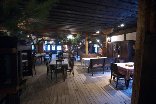 a restaurant with tables and chairs in a room at Gospoda pod Czarnym Łabędziem in Rydzewo