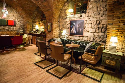 a room with a stone wall with a table and chairs at MuziKafe - Home of Culture in Ptuj