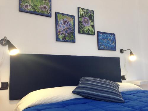 a bedroom with a bed with four pictures on the wall at Agriturismo Giorgi appartamenti in Riviera Ligure in Albenga