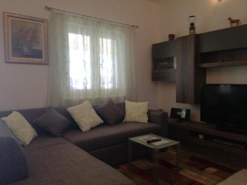 a living room with a couch and a television at Apartment Bura in Nečujam