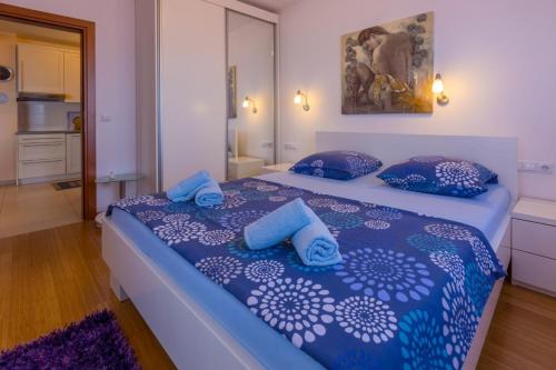 um quarto com uma cama com lençóis e almofadas azuis em Apartment em Crikvenica