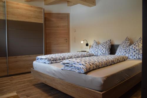 ホッホフィルツェンにあるFerienwohnung Trixlのベッドルーム1室(青と白の枕が備わるベッド1台付)