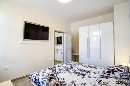 - une chambre avec un lit et une télévision murale dans l'établissement Apartment Emilija, à Pula