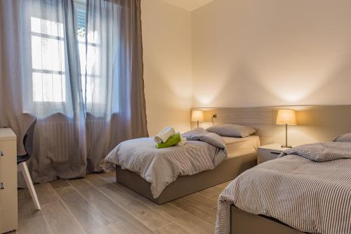 パドヴァにあるC-Apartment Civico88のベッドルーム1室(ベッド2台、窓付)