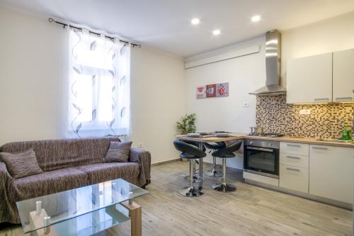 Il dispose d'une cuisine et d'un salon avec un canapé et une table. dans l'établissement Apartment Emilija, à Pula