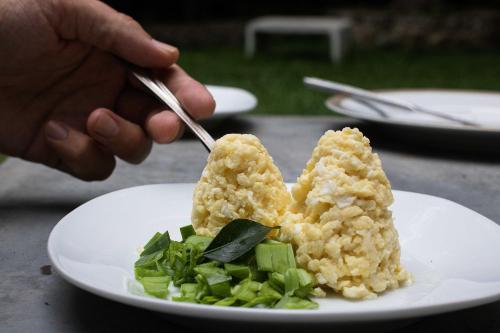 a person holding a fork and a plate of food at Villa Taprobane in Negombo