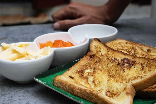 a green plate with toast and a bowl of vegetables at Villa Taprobane in Negombo
