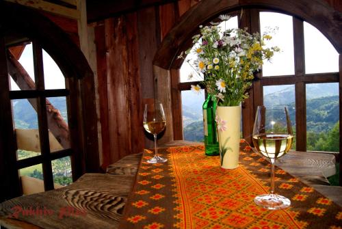 a table with two glasses of wine and flowers at Rakhiv Plai in Rakhiv