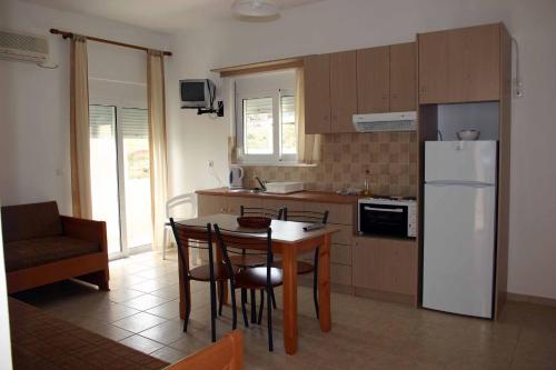 a kitchen with a table and a white refrigerator at Evilion hotel in Stalos