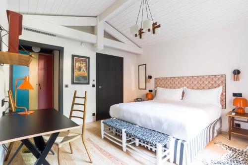 une chambre avec un grand lit et une table dans l'établissement La Guitoune, à Pyla-sur-Mer