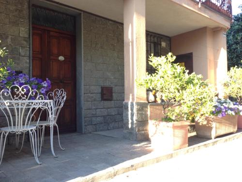 a porch with a table and chairs and flowers at Agriturismo Giorgi appartamenti in Riviera Ligure in Albenga