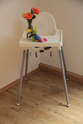 a small white table with a vase of flowers on it at Alice nahe EuropaPark Rulantica in Kappel-Grafenhausen