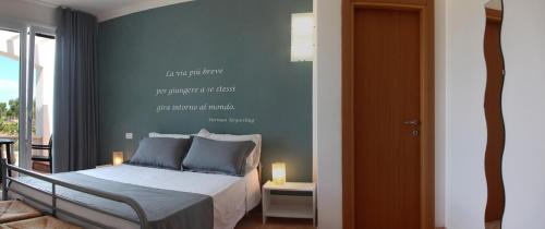 a bedroom with a bed with a quote on the wall at Villa Giulia&Gaia - Guest House in Nardò