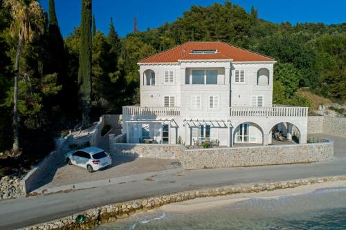 a white car parked in front of a house at Apartments Villa D&D in Slano