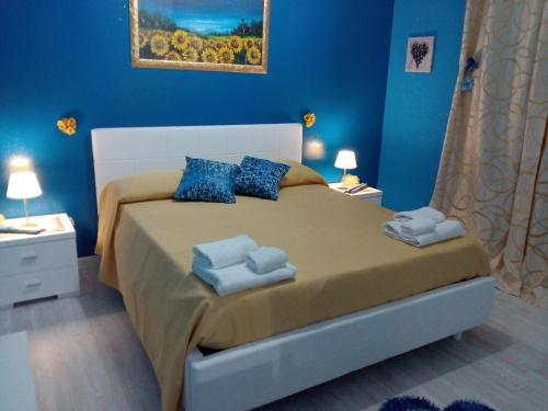a bedroom with a large bed with blue walls at Etna En Vie in Zafferana Etnea