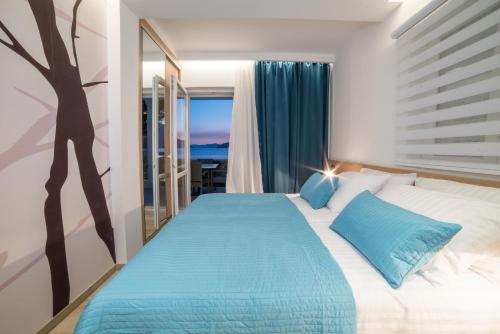 a bedroom with a large bed with blue pillows at Apartments Villa D&D in Slano