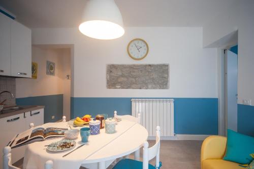 a kitchen with a table and a clock on the wall at Un soffio dal cielo in Beverino