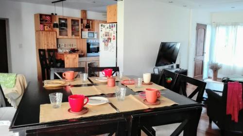 
a kitchen with a table, chairs, and a table cloth at La casa de Silvia in Puerto Madryn
