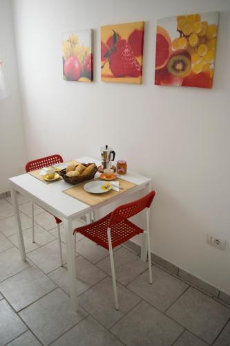a white table and chairs with a plate of food on it at Salentum Villa Miami - con ampia terrazza in Vignacastrisi