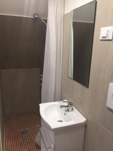 a bathroom with a sink and a mirror and a shower at San Domenico in Mola di Bari