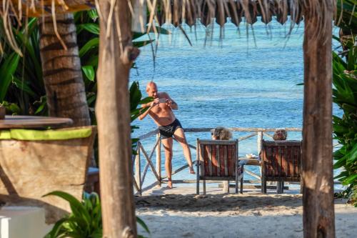 a man playing baseball on the beach at Seasons Lodge Zanzibar in Pongwe
