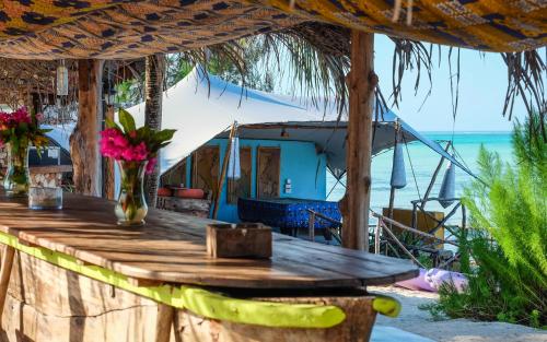 a wooden bar with a view of the ocean at Seasons Lodge Zanzibar in Pongwe