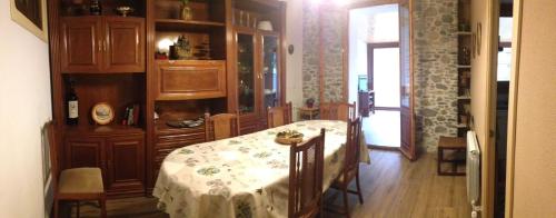 a dining room with a table with a white table cloth at Allotjament Taga in Ribes de Freser