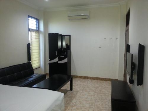 a living room with a couch and a table in a room at Discovery Homestay in Makassar