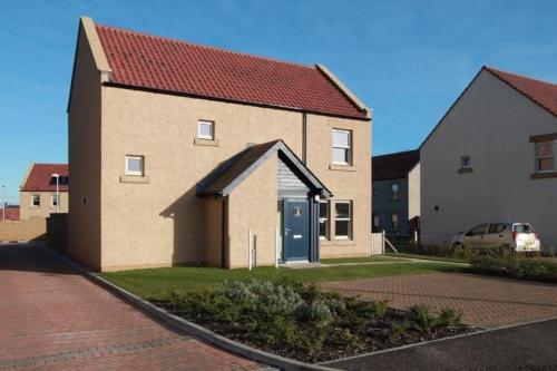 a large brick building with a red roof at The View, 22 School Park in Kingsbarns