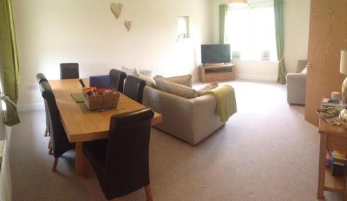 a living room with a table and a couch at The View, 22 School Park in Kingsbarns