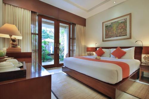 una grande camera da letto con un grande letto e una scrivania di Tebesaya Cottage by Pramana Villas ad Ubud