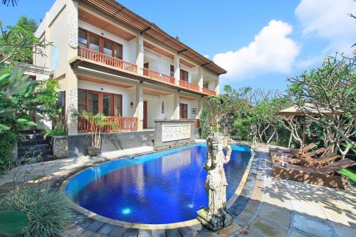 a swimming pool in front of a house at Tebesaya Cottage by Pramana Villas in Ubud