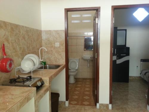 a kitchen with a sink and a toilet in a room at Discovery Homestay in Makassar