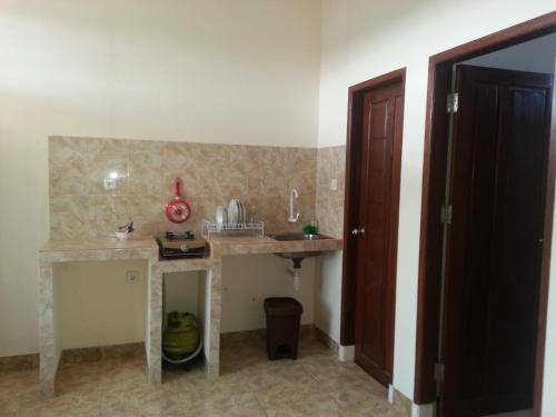 a kitchen with a counter and a sink in a room at Discovery Homestay in Makassar