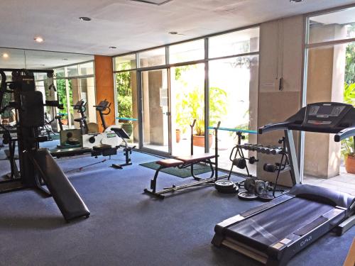 a gym with several treadmills and machines in it at Rio Monte Residence in Bangkok