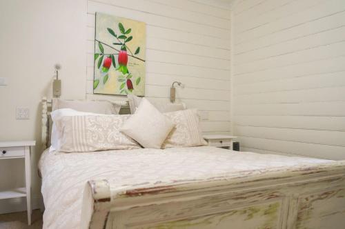 a bedroom with a large bed with white sheets at Twodogfolly in Armidale