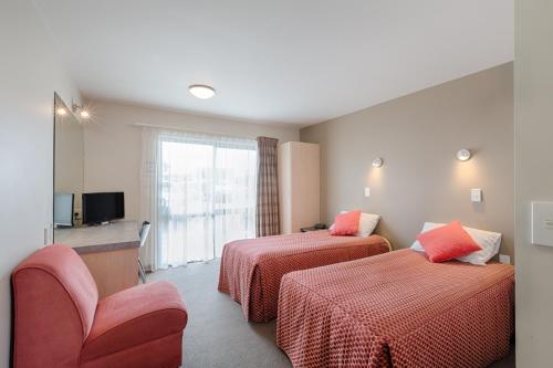 a hotel room with two beds and a television at Bella Vista Motel Rotorua in Rotorua