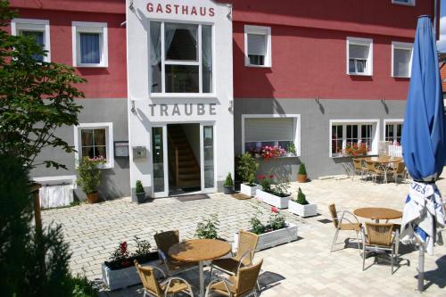a restaurant with tables and chairs in front of a building at Gasthaus Traube in Dettingen an der Erms