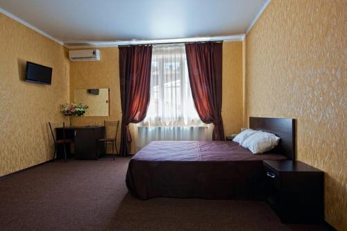 a hotel room with a bed and a window at Provans Guest House in Krasnodar