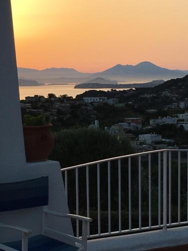 a bench on a balcony with the sunset in the background at Poggio Aragosta Hotel & Spa in Ischia