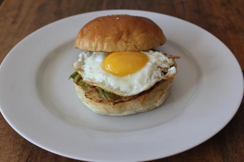 a sandwich with an egg on a white plate at Mahi Mahi House in Nusa Lembongan