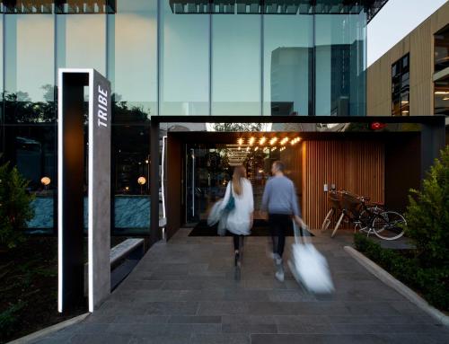 a man and woman walking into a building with shopping bags at Tribe Perth in Perth