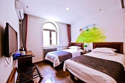 a hotel room with two beds and a painting on the wall at Nostalgia Hotel Beijing South Luogu Lane, Ghost Street, Beixinqiao Metro Station in Beijing
