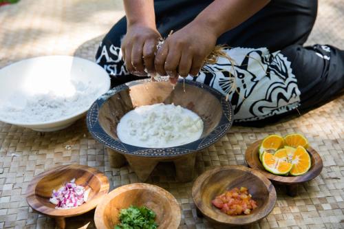 a person sitting on the ground with a bowl of food at Castaway Island, Fiji in Castaway Island