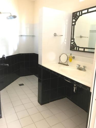 a bathroom with a sink and a mirror at Cabilao Sunset Dive & Beach Resort in Loon