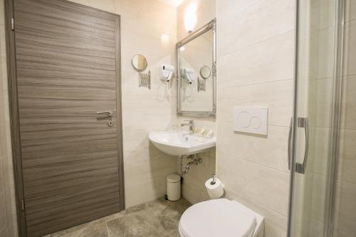 a bathroom with a toilet and a sink at Barbara Piran Beach Hotel in Piran