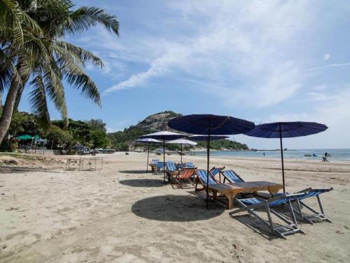 a group of chairs and umbrellas on a beach at Ban View Viman Condo in Hua Hin